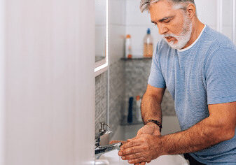 man in bathroom using antibacterial soap for penis cleaning